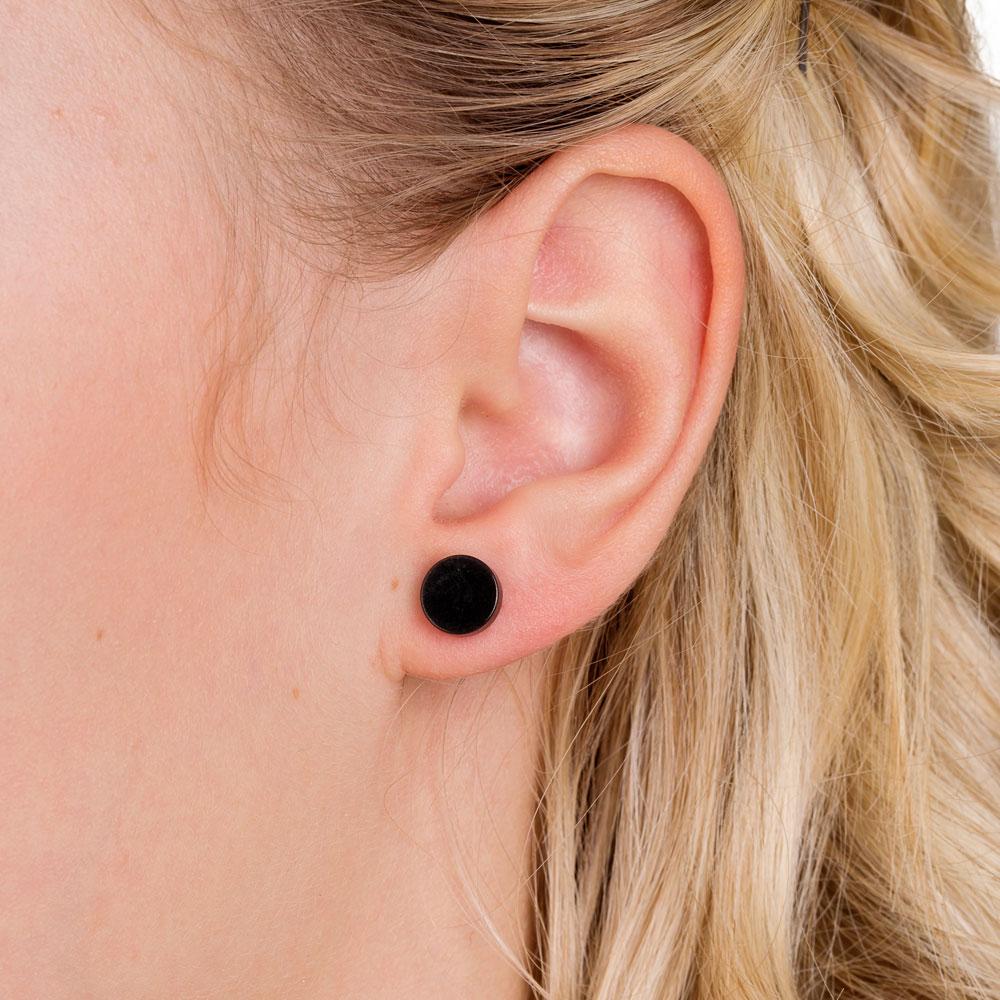 Female model black titanium nickel-free puck earrings